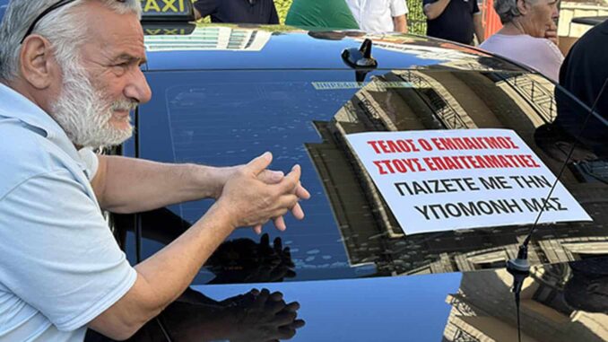 „Сложете край на подигравките, играете си с нашето търпение“ гласи плакат на предното стъкло на такси в Никозия (Снимка: Христос Теодоридес)
